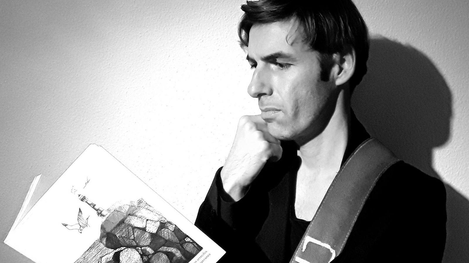 Alexandre Lacaze leyendo un ejemplar de su ilbro, 'Los arrecifes de la esperanza'