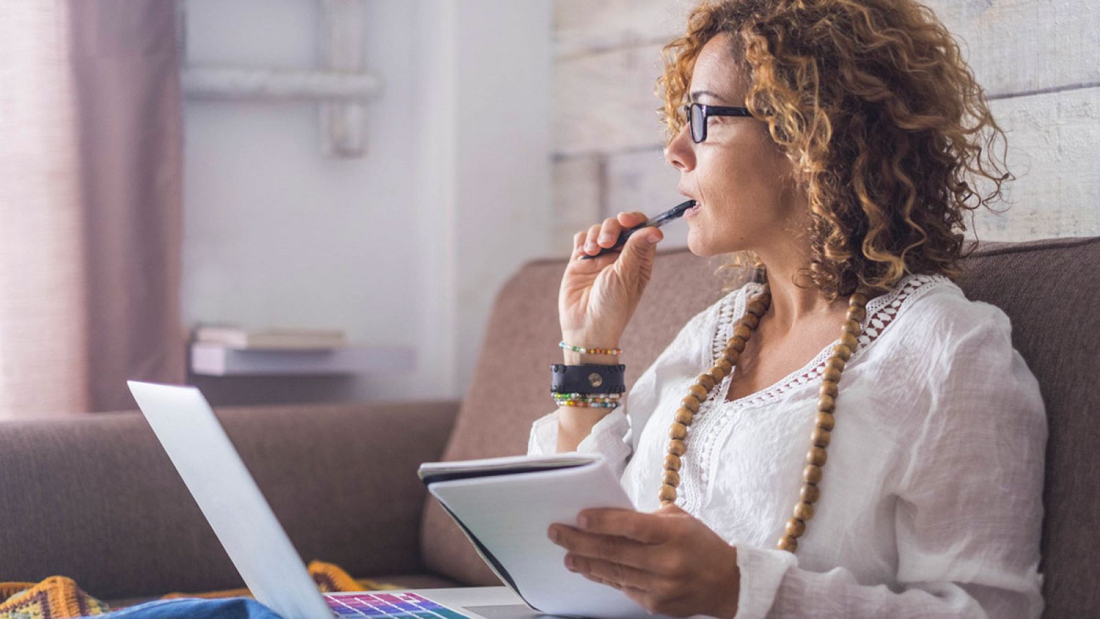 Una mujer mira por la ventana en su casa