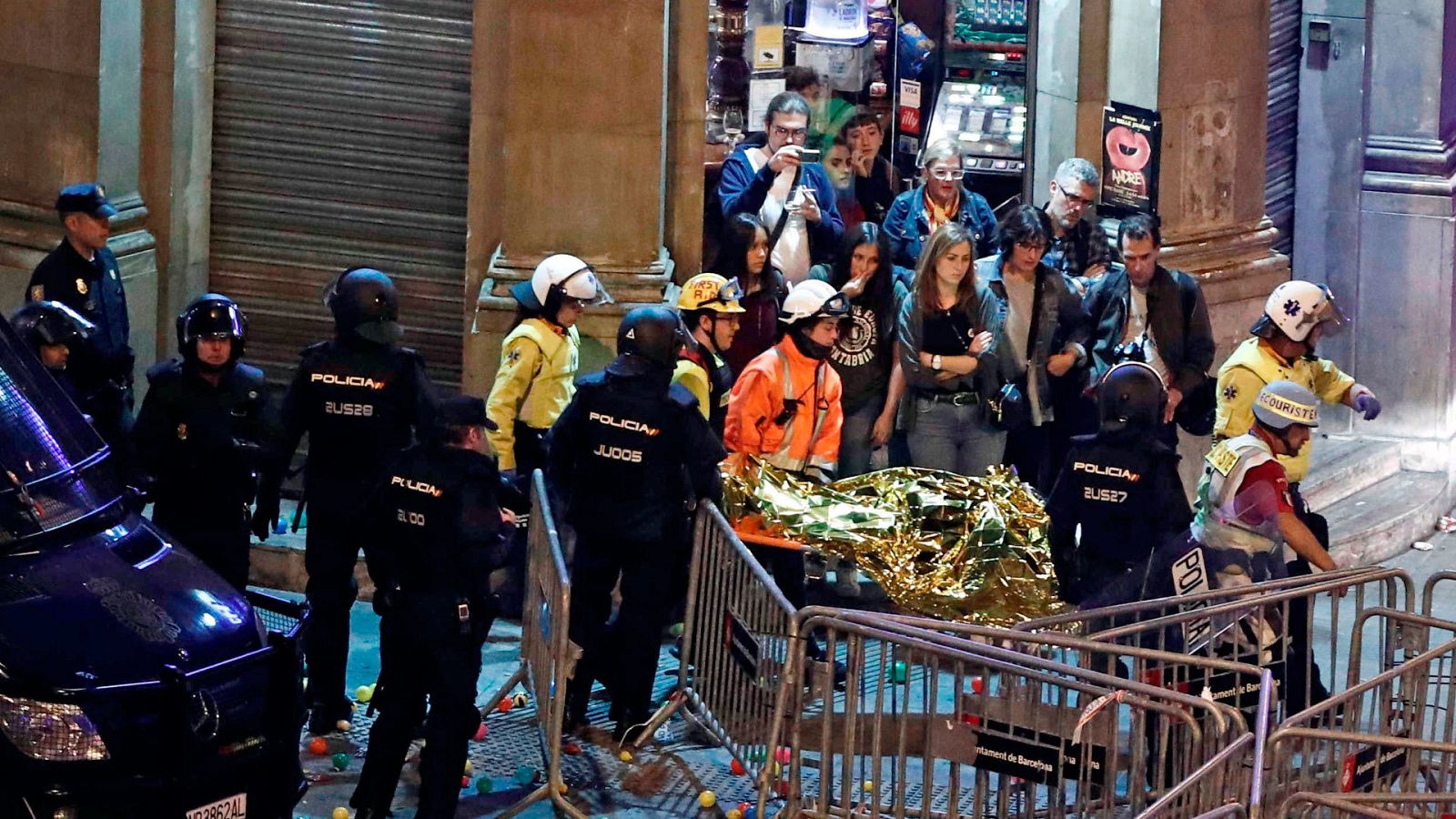 Varios sanitarios transportan a un herido en los enfentamientos de Barcelona