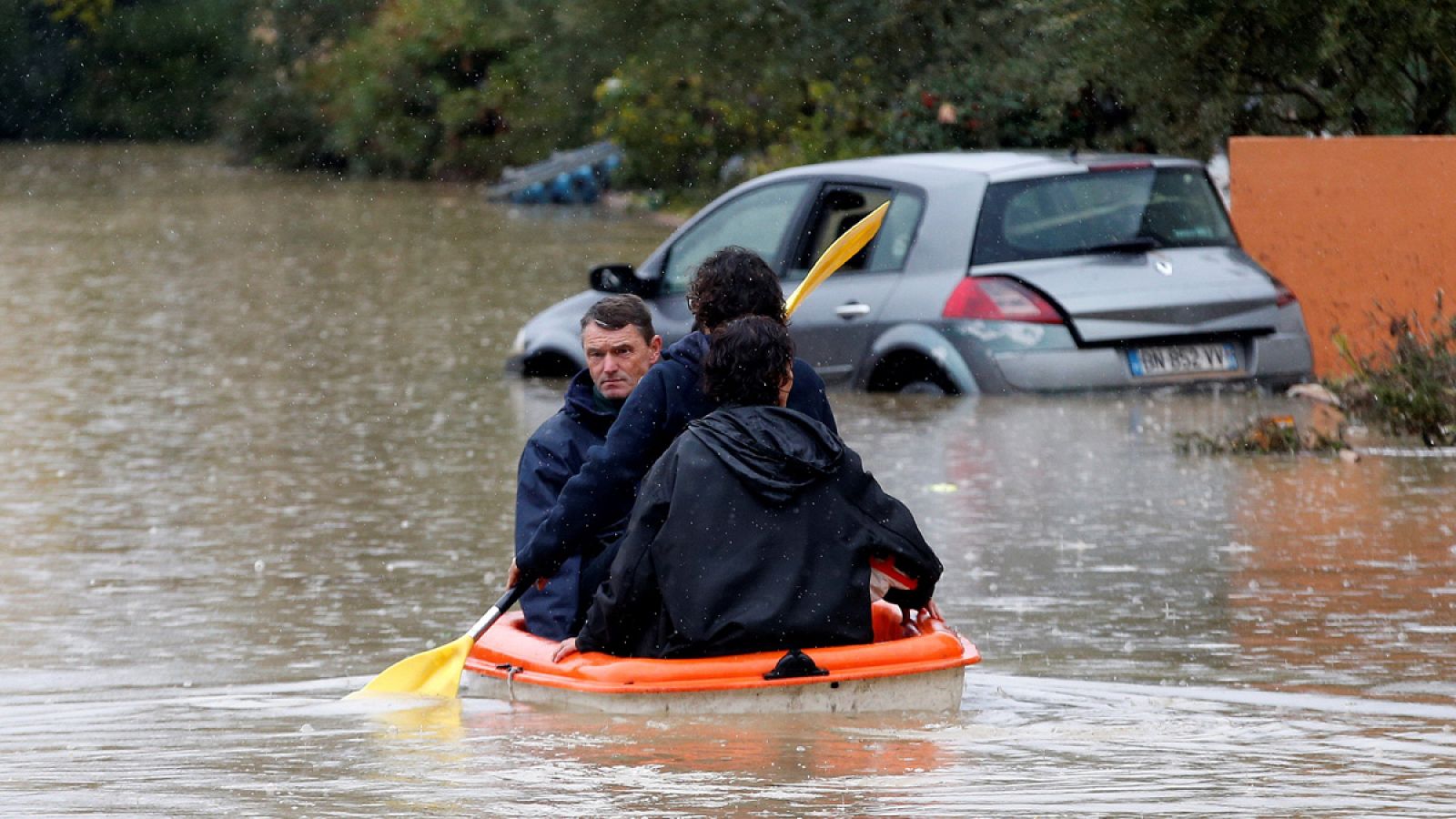 Unas personas usan una canoa en medio de calles sumergidas en Le Muy