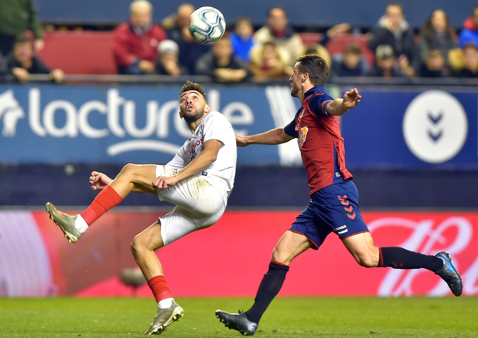 El sevillista Munir El Haddadi  (l) lucha por el balón con el osasunista Oier Sanjurjo