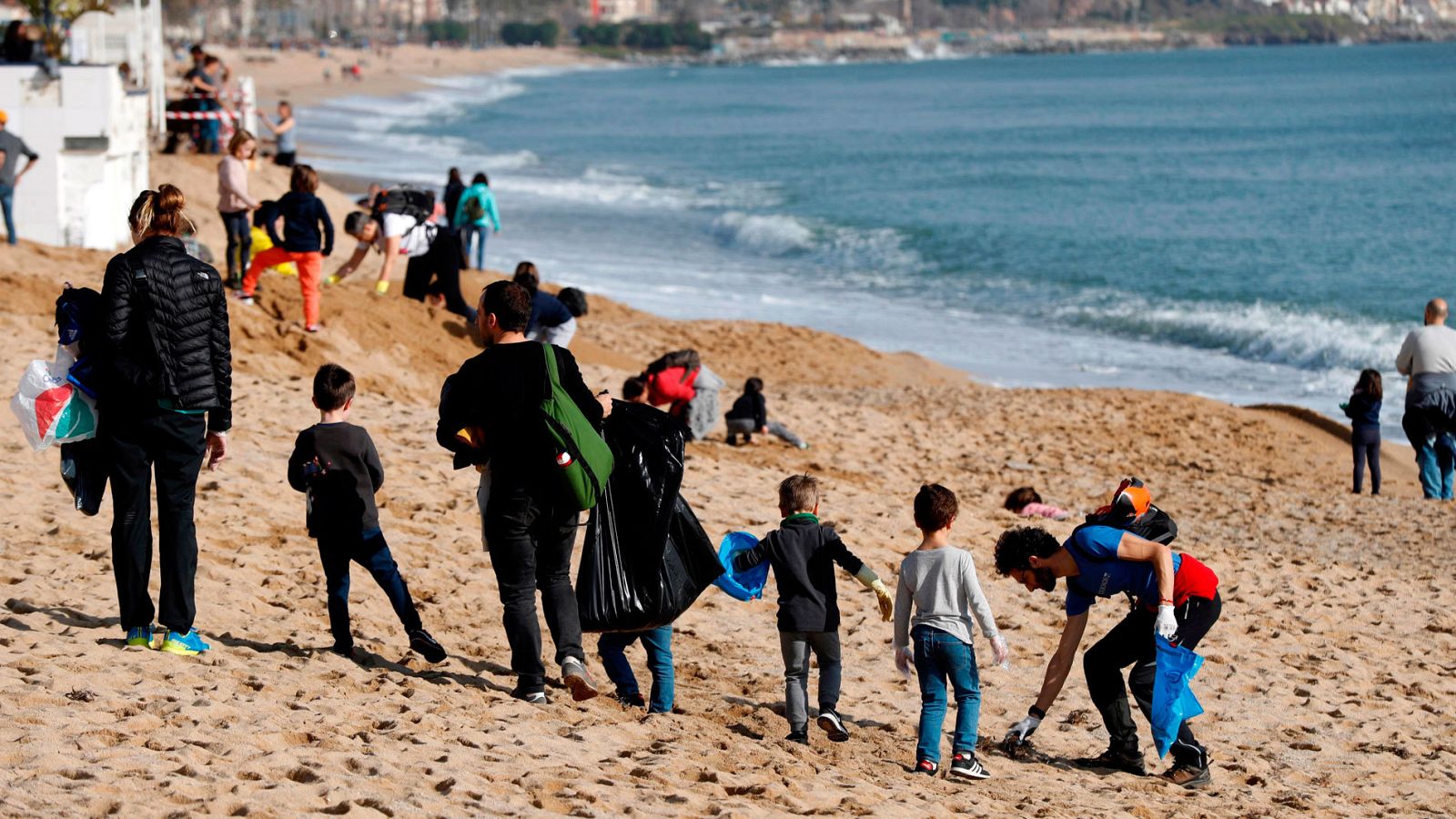 Voluntarios ayudan a limpiar las playas de Badalona tras el paso del temporal 'Gloria'