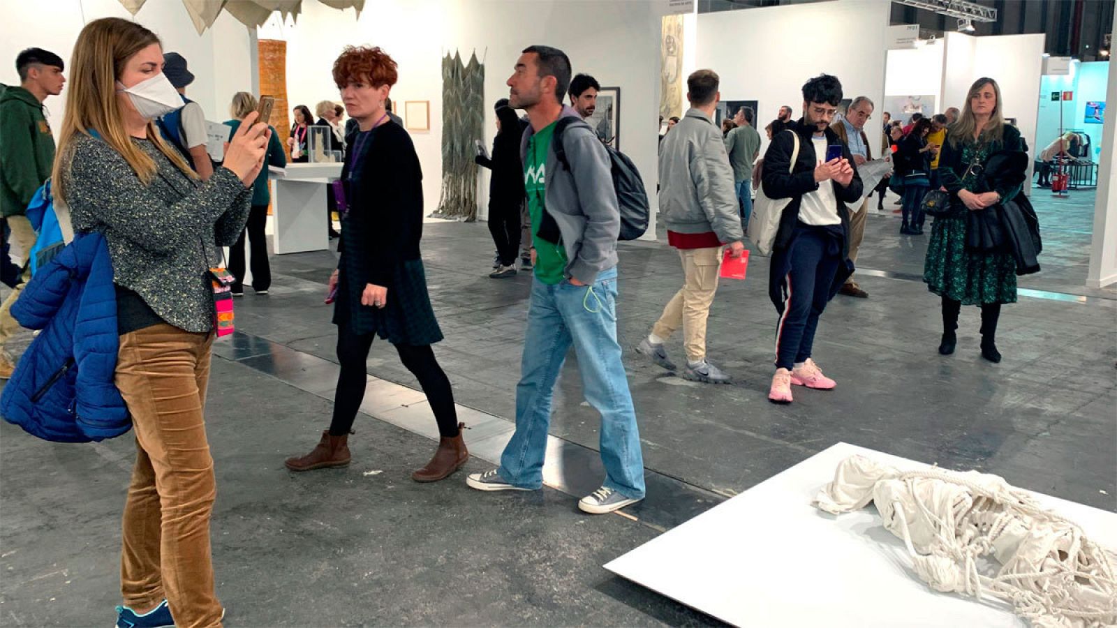 Vista de una visitante de ARCO ataviada con una mascarilla