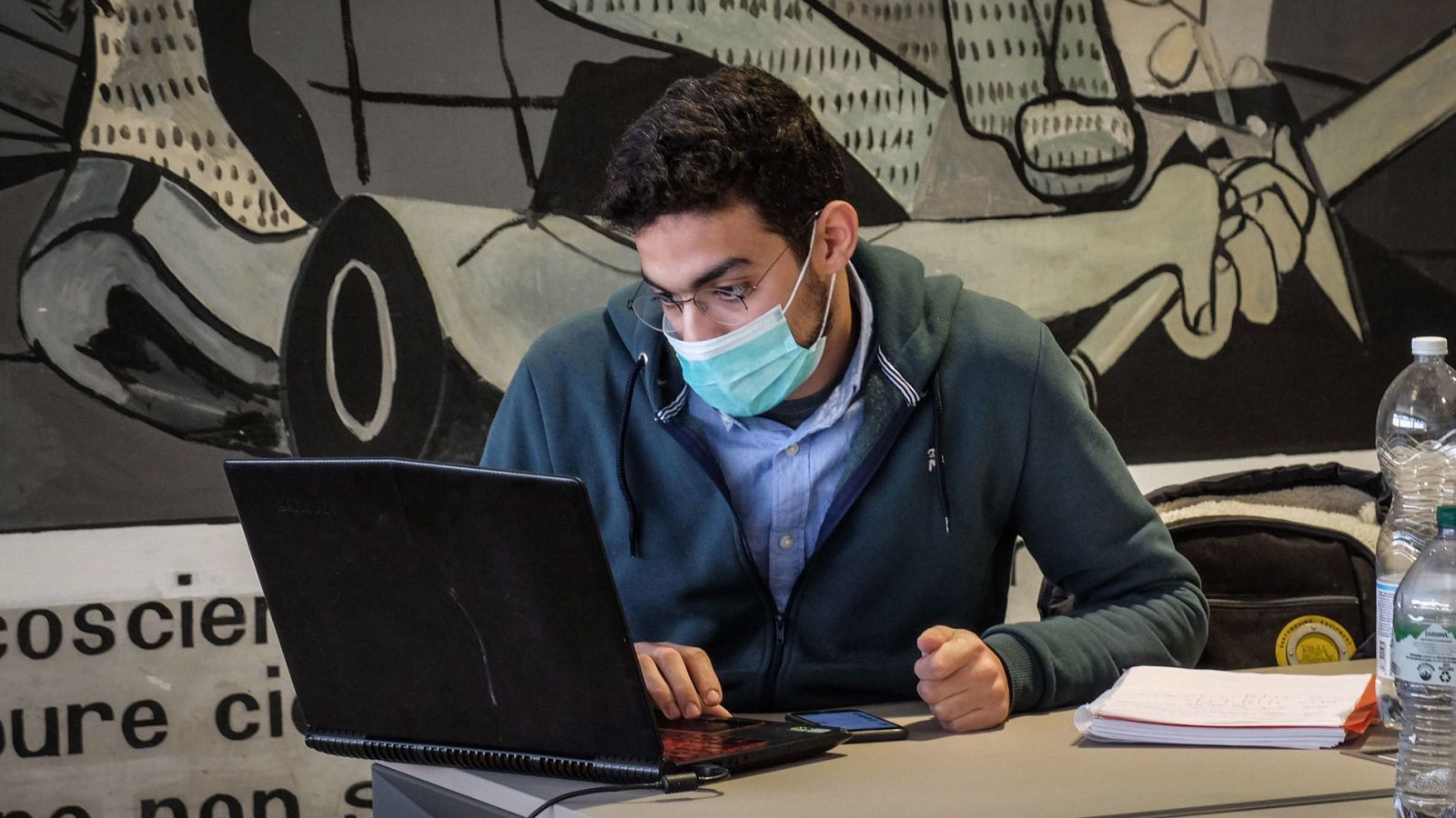 Un estudiante de la Universidad Politécnica de Milán se protege con mascarilla mientras estudia