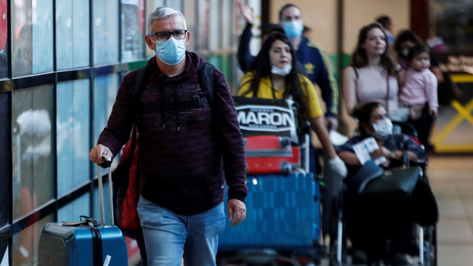Pasajeros usando mascarillas para evitar la propagación y el contagio del coronavirus en el aeropuerto