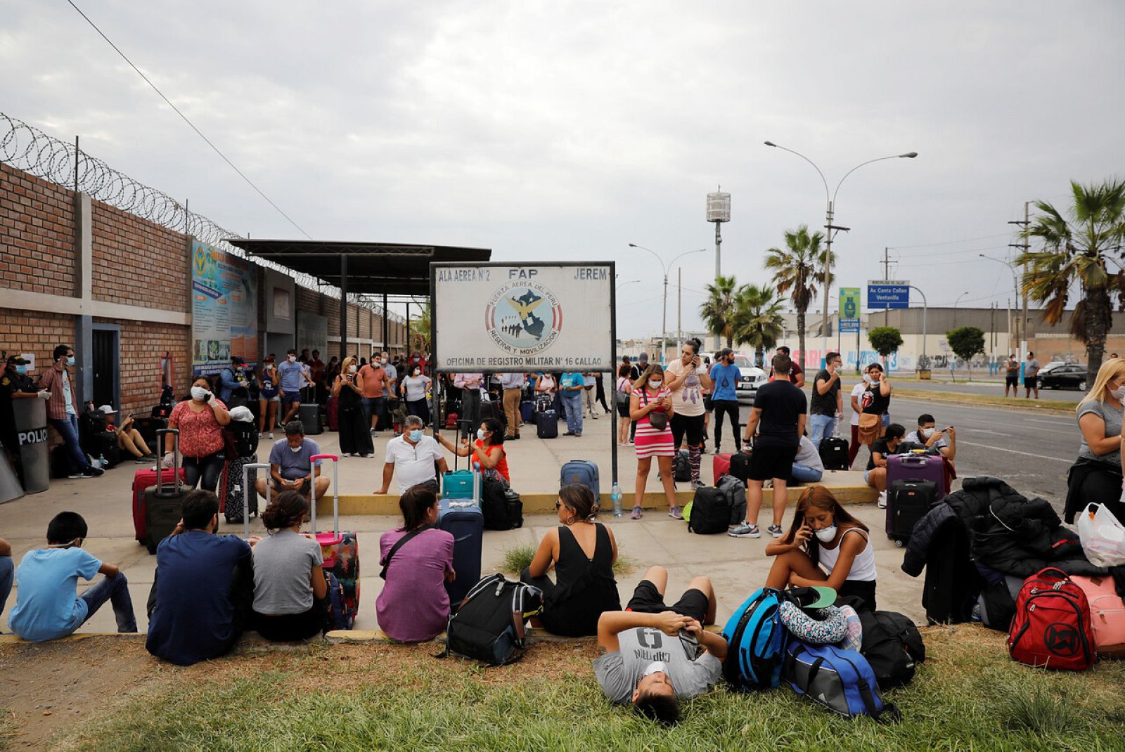 Un grupo de extranjeros espera a las afueras de un aropuerto militar en Perú