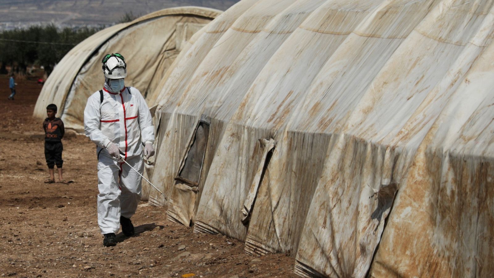 Un miembro de la Defensa Civil de Siria desinfecta una tienda de campaña en el campamento de desplazados internos de Bab Al-Nour, en Azaz, Siria
