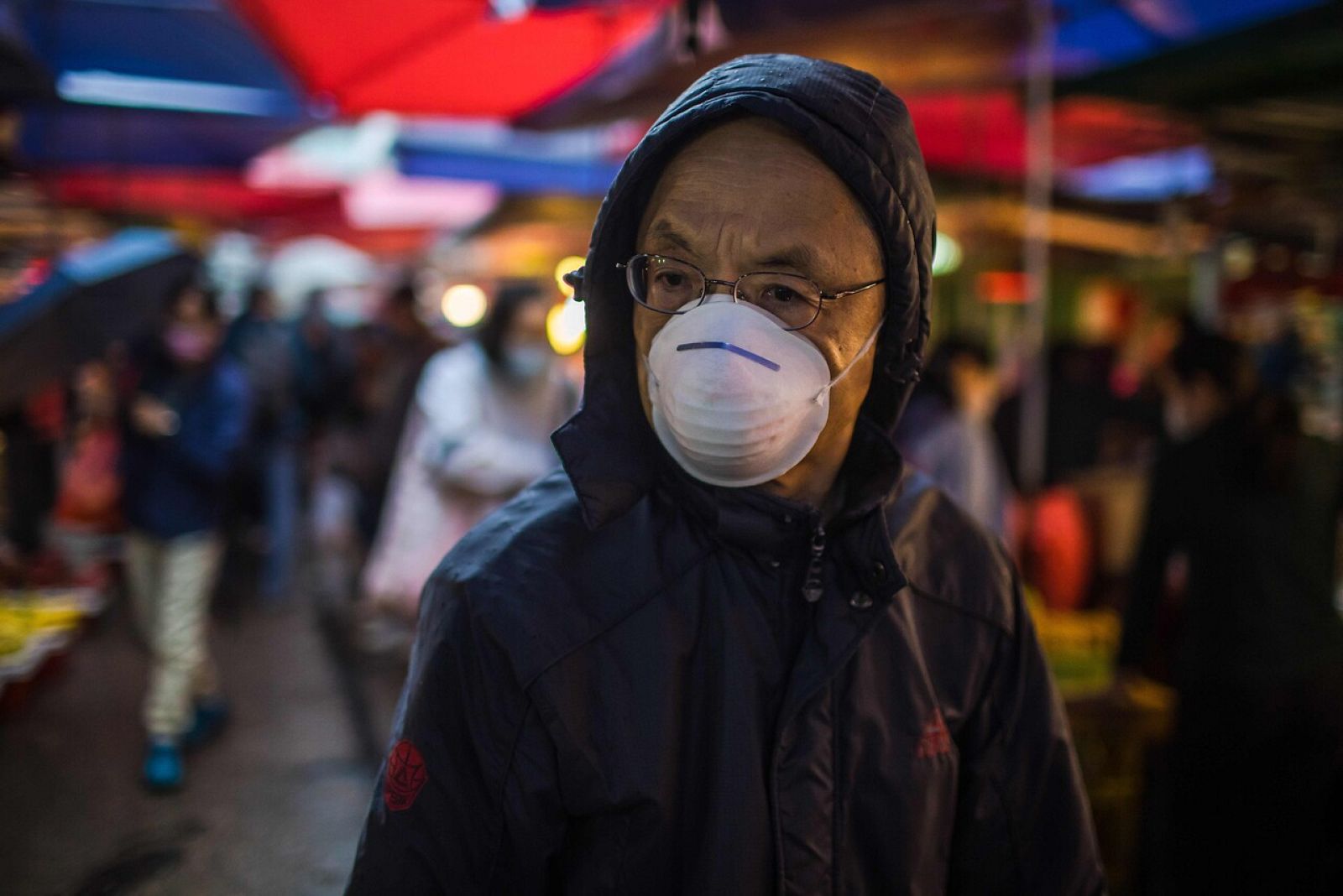 Un hombre pasea con mascarilla por un mercado de comida