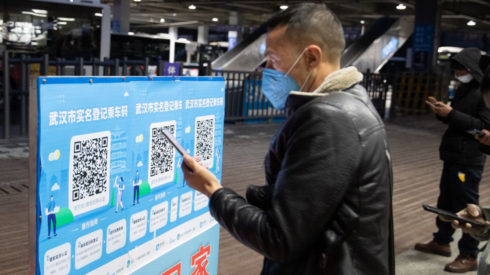 Un ciudadano escanea un código QR con su teléfono móvil enuna estación de metro en Wuhan, provincia de Hubei, en China