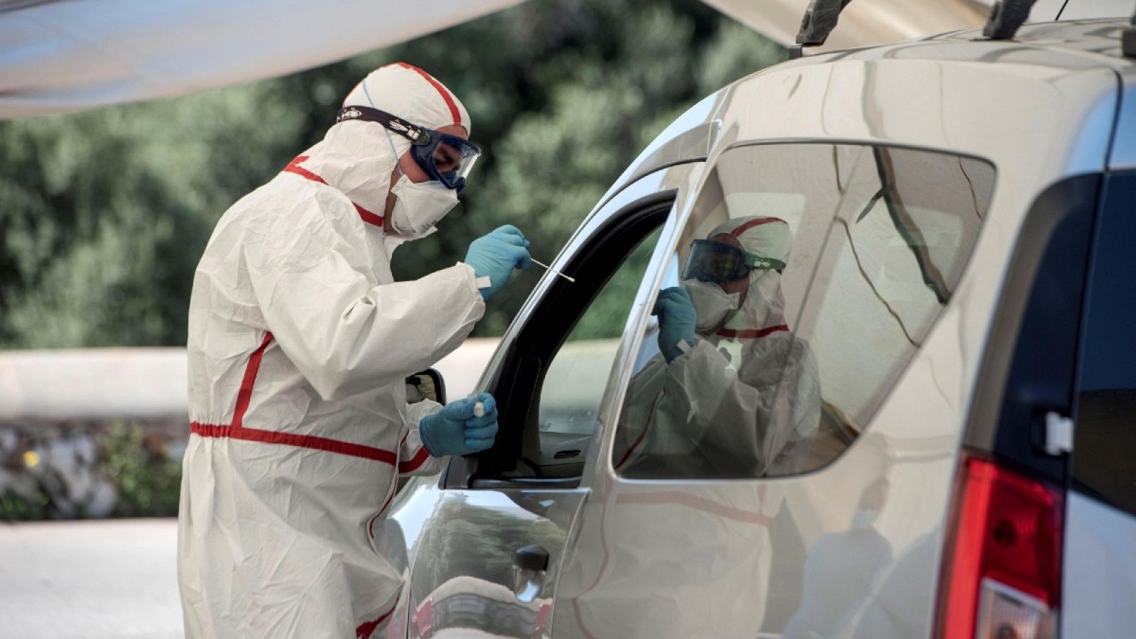 Un sanitario hace tests rápidos para detectar el coronavirus provisto de mascarilla y equipo de protección individual