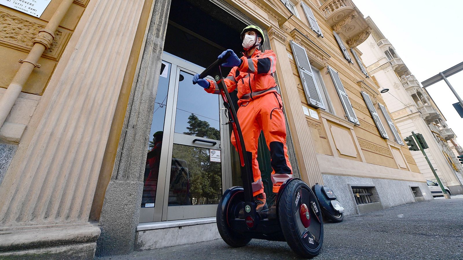 Voluntarios de Cruz Roja recorren las calles de Génova en vehículos segway ecológicos para repartir mascarillas y medicinas a domicilio.