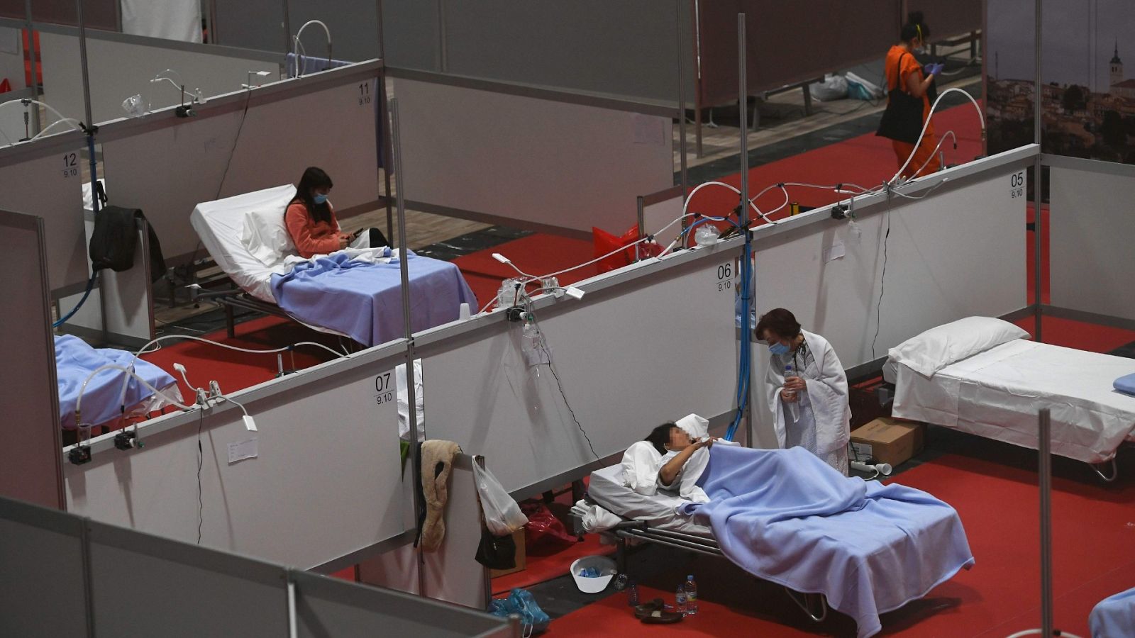 Un sanitario conversa con un paciente en el hospital habilitado en IFEMA