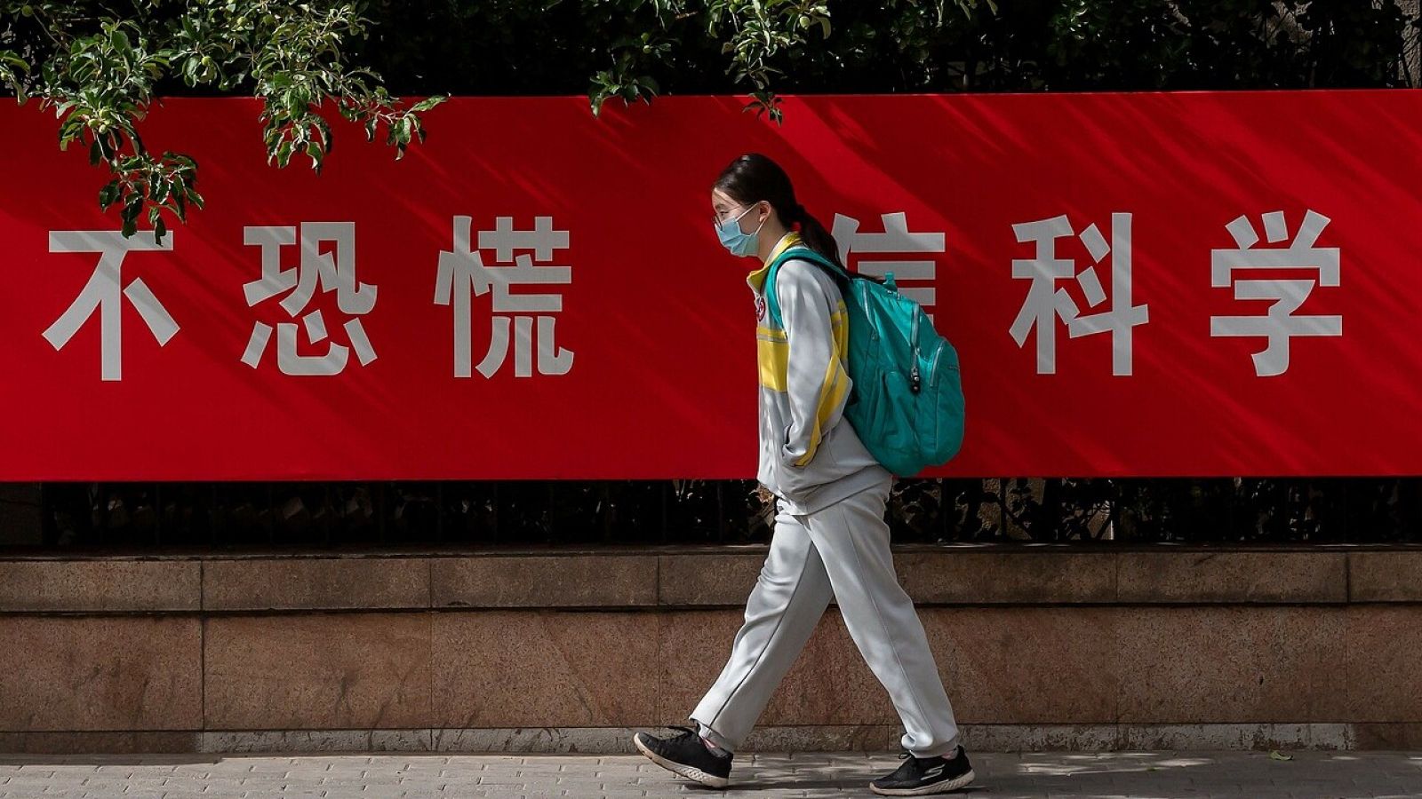 Una estudiante camina por una calle de Pekín