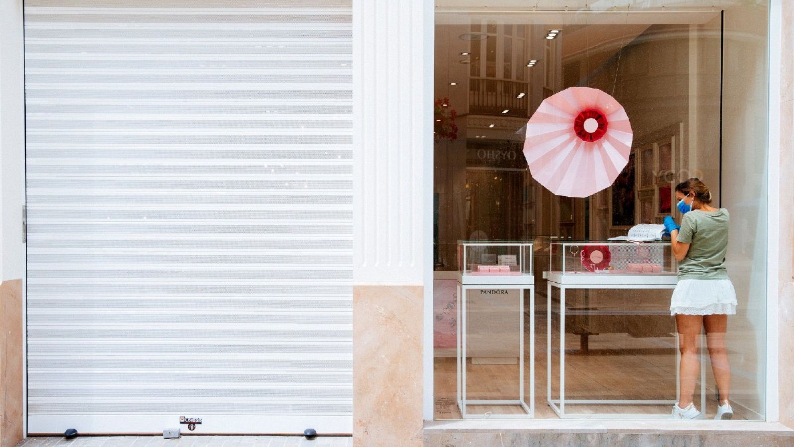 Una trabajadora prepara un establecimiento en el centro de Málaga que pasará el lunes, 18 de mayo, a Fase 1