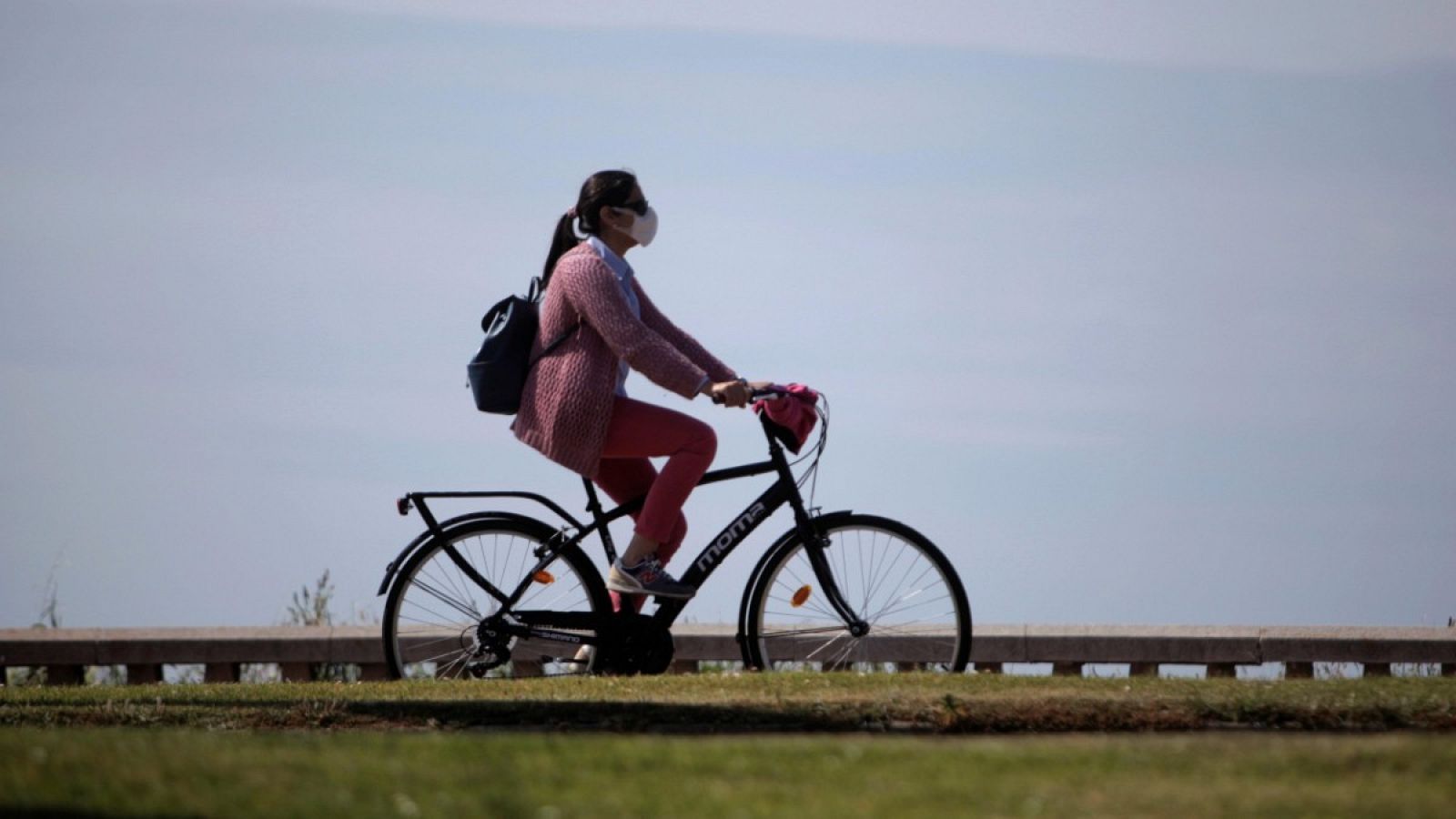 Una mujer con mascarilla circula en bicicleta por A Coruña