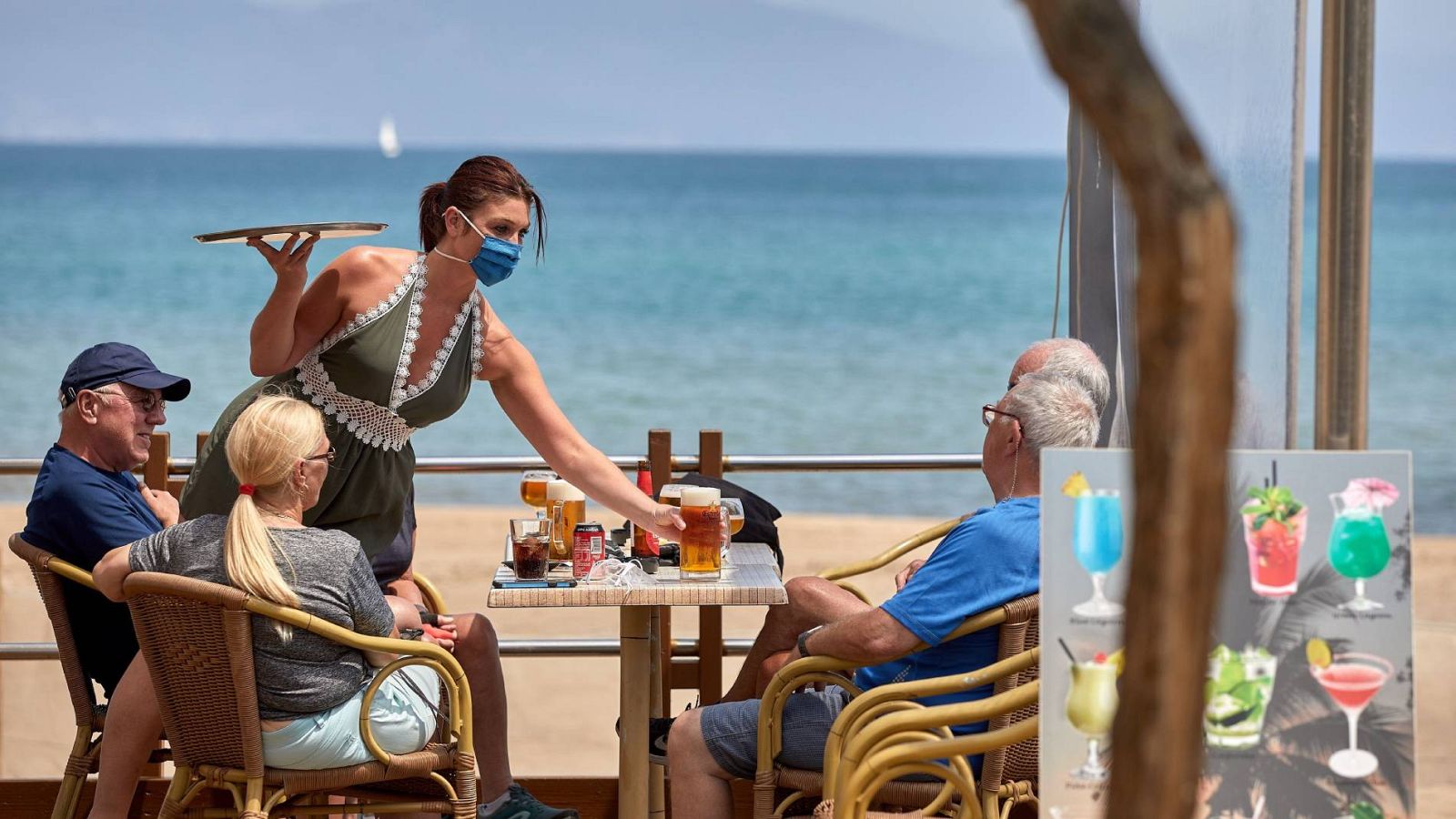 Una camarera sirve unas bebidas en una terraza de L'Escala (Girona) este jueves mientras Girona se mantiene en la Fase 1 de la desescalada
