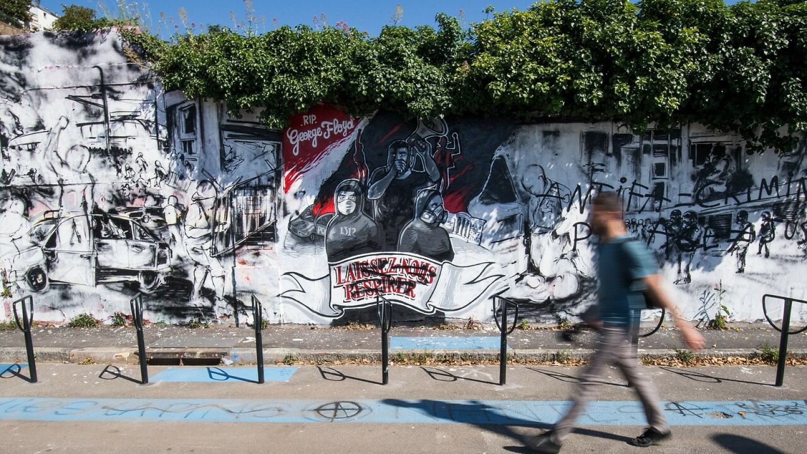 Un peatón camina ante un mural que homenajea al fallecido George Floyd