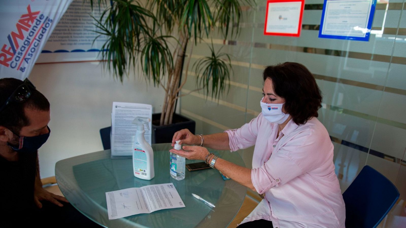 Una agente inmobiliaria muestra un impreso a un cliente