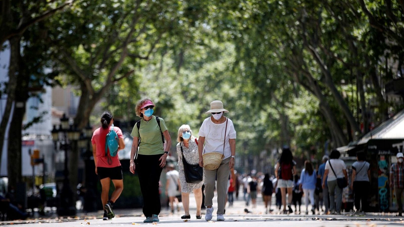 Personas pasean durante el primer día tras el fin del estado de alarma, este domingo, durante la "nueva normalidad", este domingo en Las Ramblas, Barcelona.