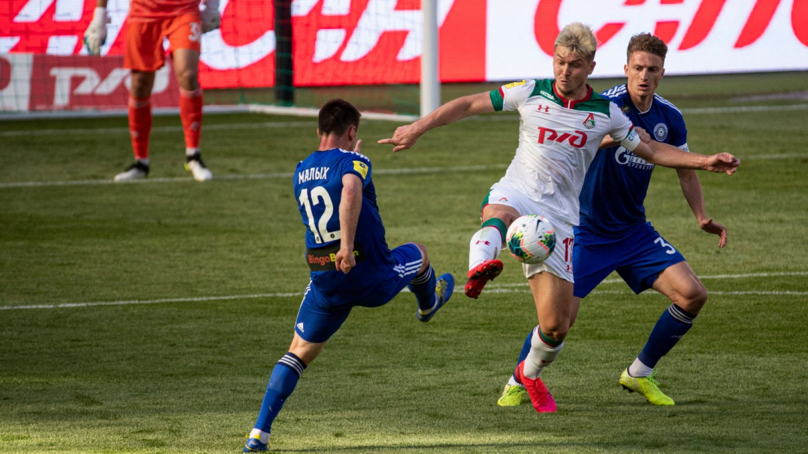 Zhemaletdinov (c), del Lokomotiv de Moscú, pelea por el balón con Malih (i) y Shakhov (d), del Orenburg