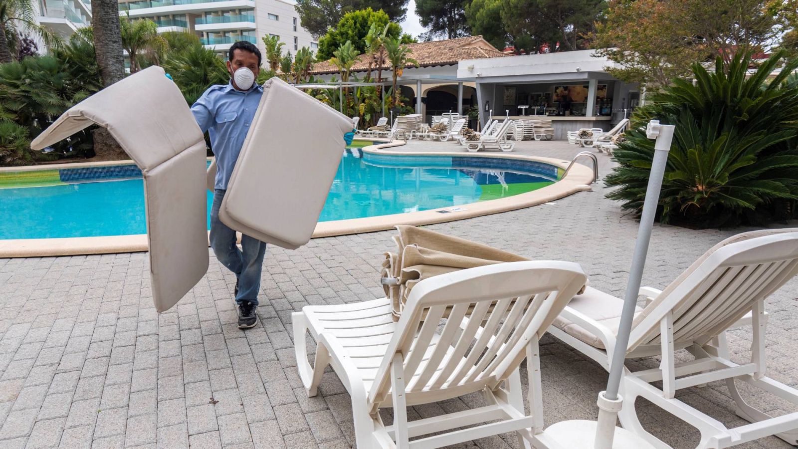 Un trabajador de un hotel prepara las zonas exteriores del complejo para recibir a los turistas