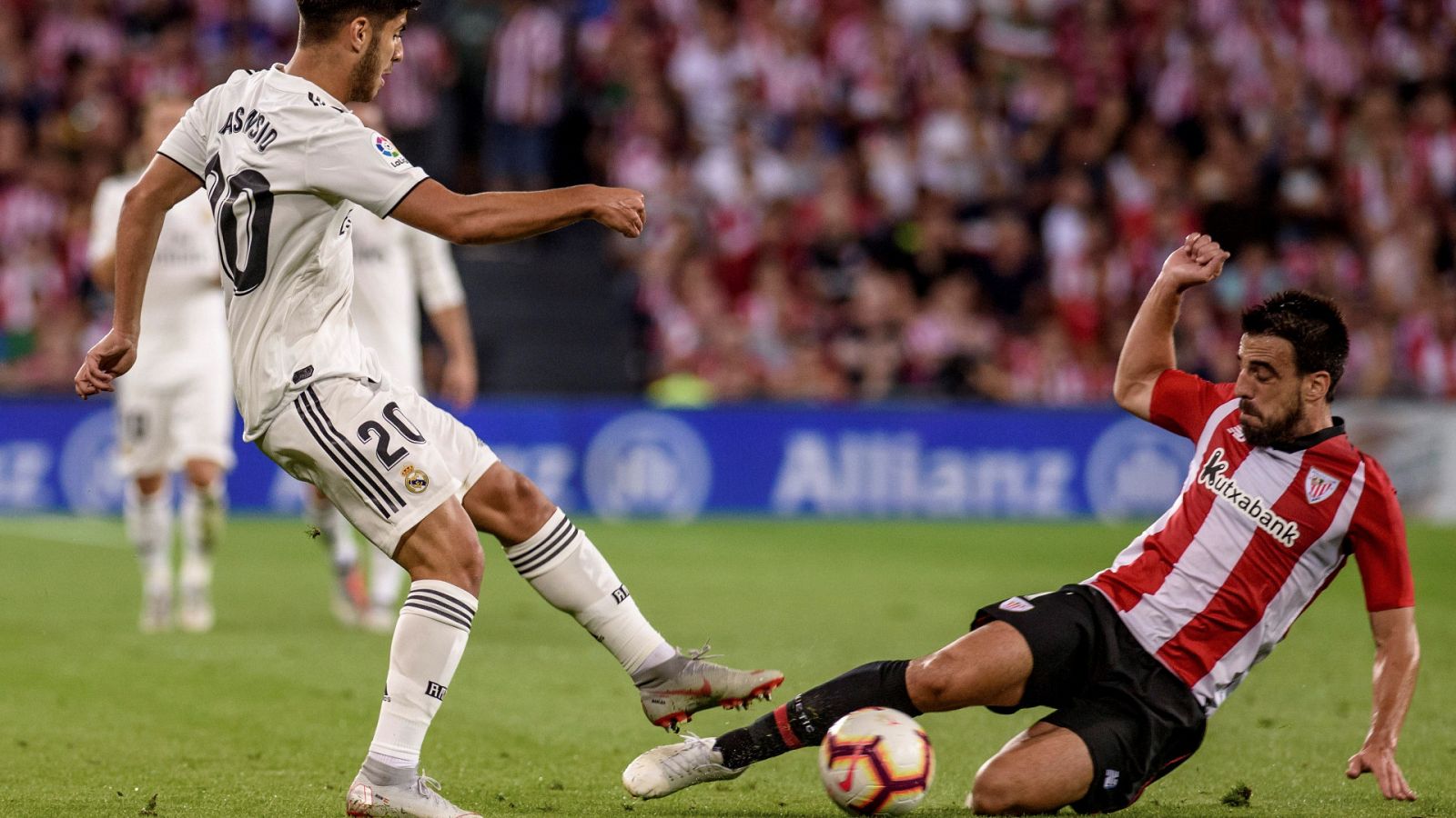 Marco Asensio pugna con Beñat durante un partido en San Mamés.