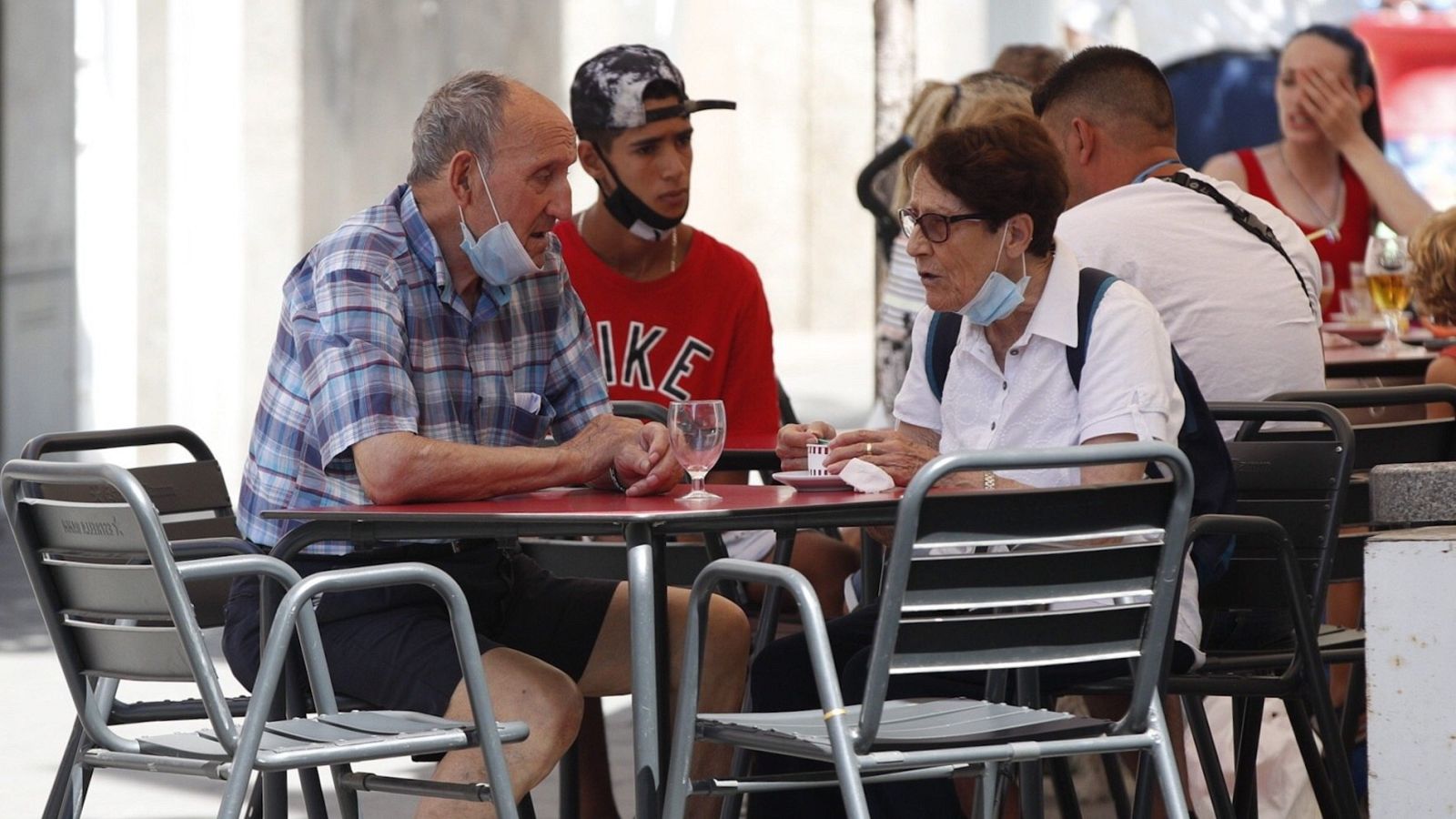 Varias personas en una terraza del barrio de La Torrassa en l'Hospitalet (Barcelona)