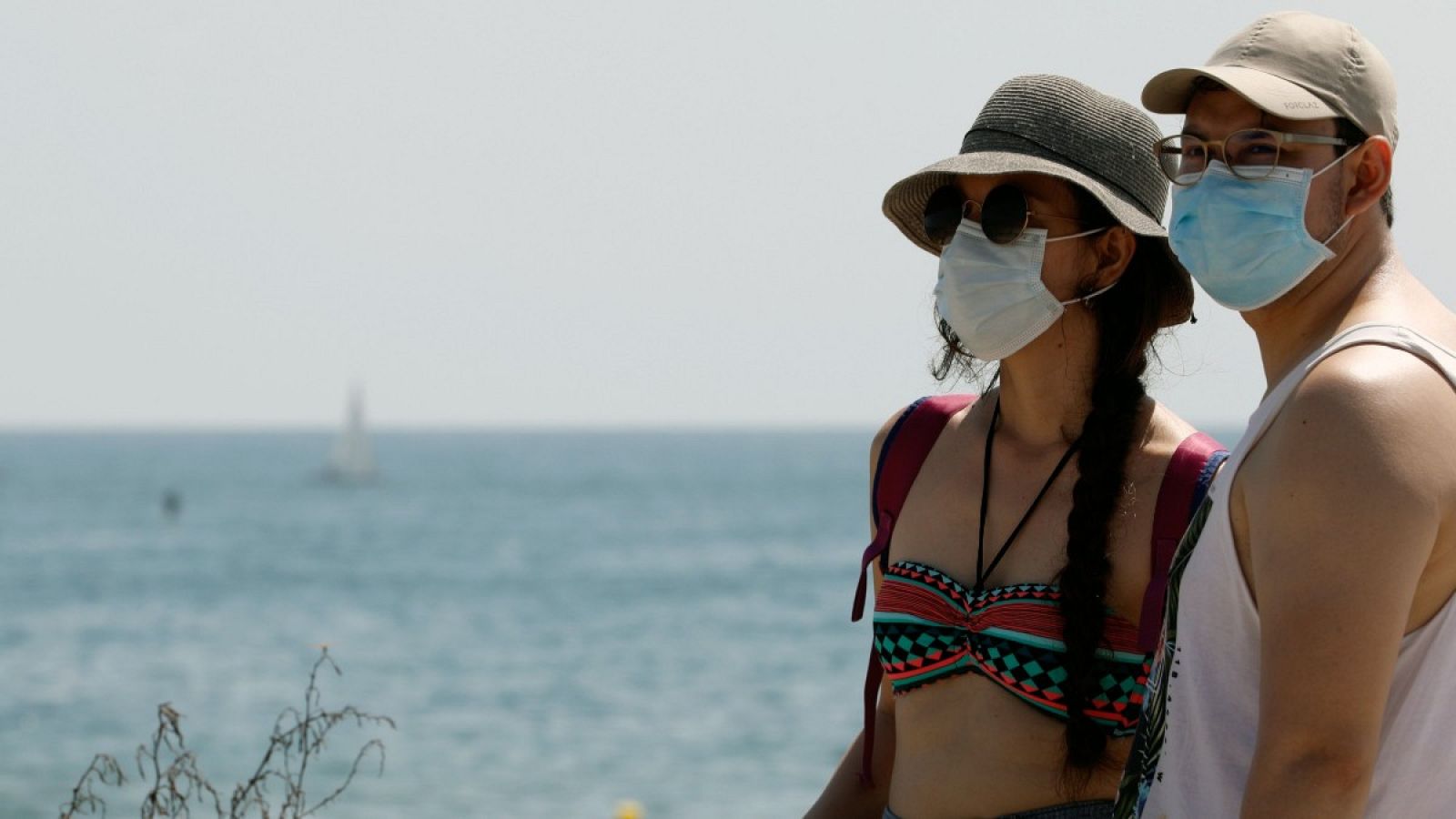 Dos personas protegidas con mascarillas en la playa de la Malvarrosa de Valencia