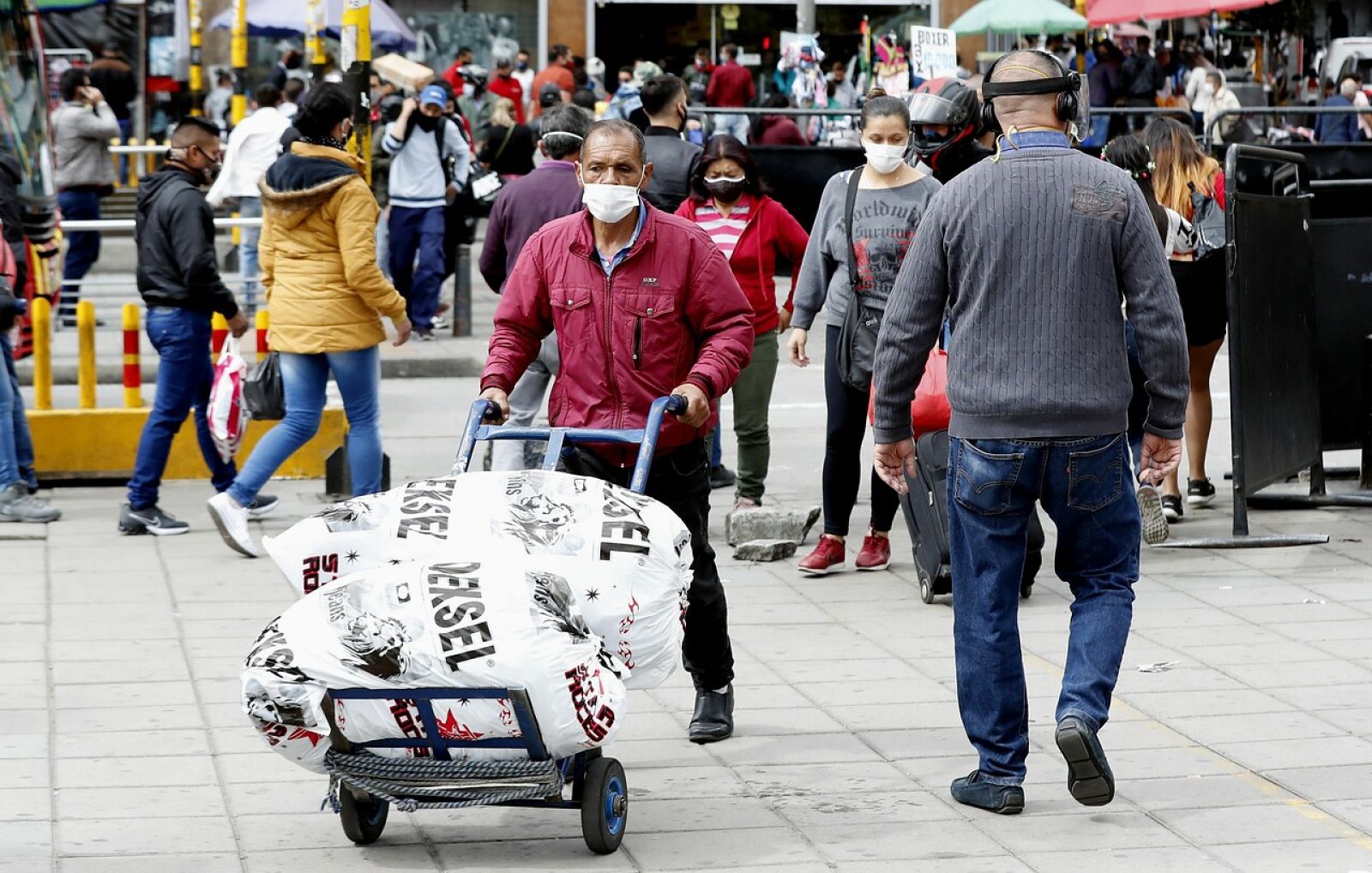 Personas con mascarilla caminan por el sector de San Victorino en Bogotá (Colombia)