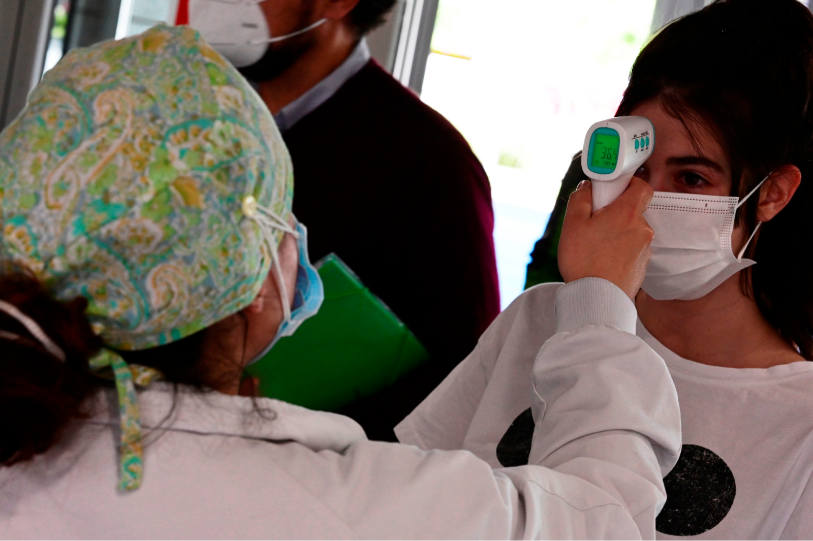 Un sanitario toma la temperatura a una mujer.