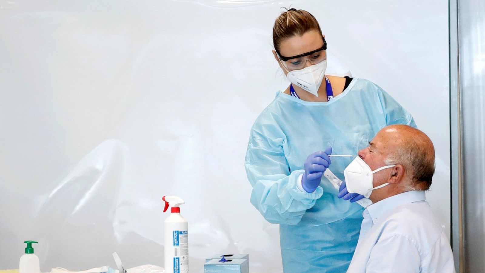 Una sanitaria hace una PCR a un paciente