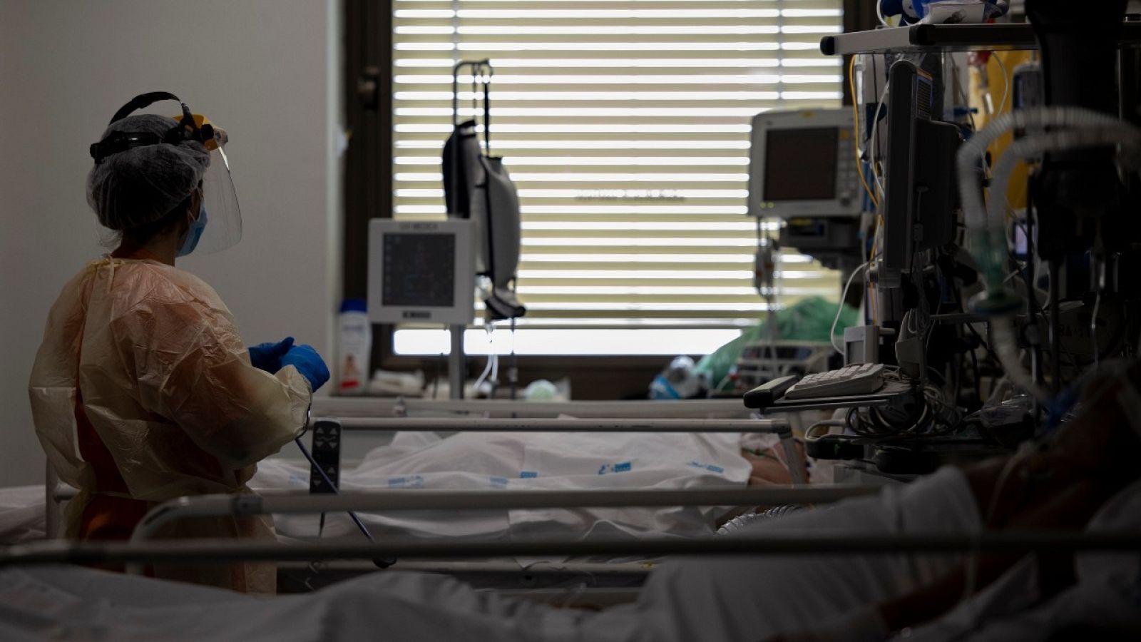 n sanitario atiende a un paciente en la UCI dedicada a enfermos de coronavirus del Hospital Universitario Ramón y Cajal