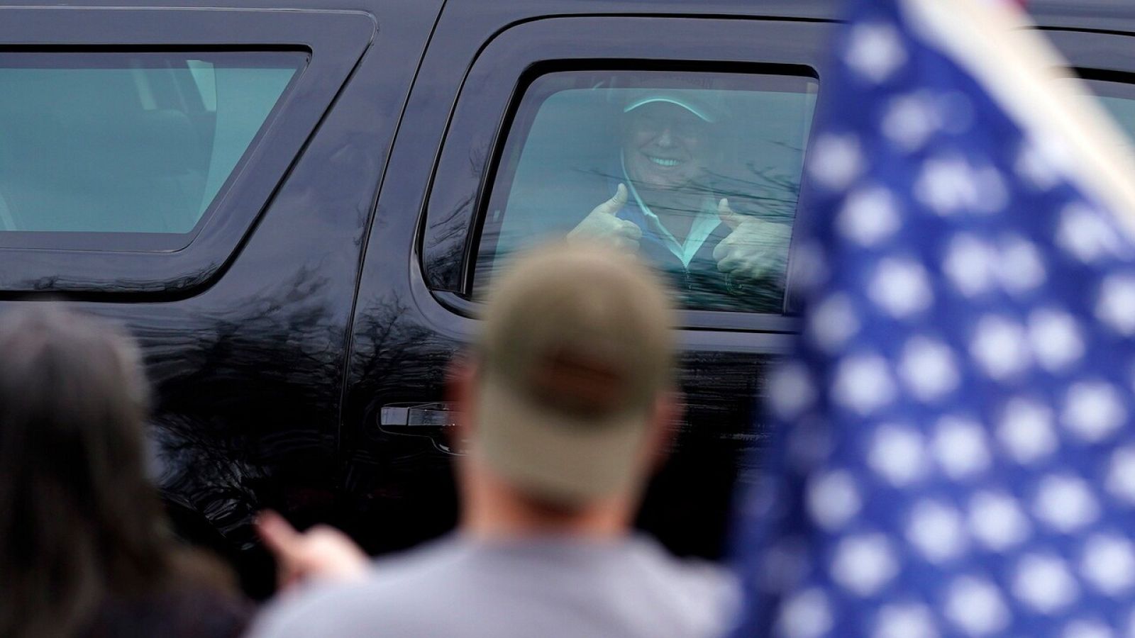 Trump saluda a sus seguidores desde el coche tras terminar de jugar al golf