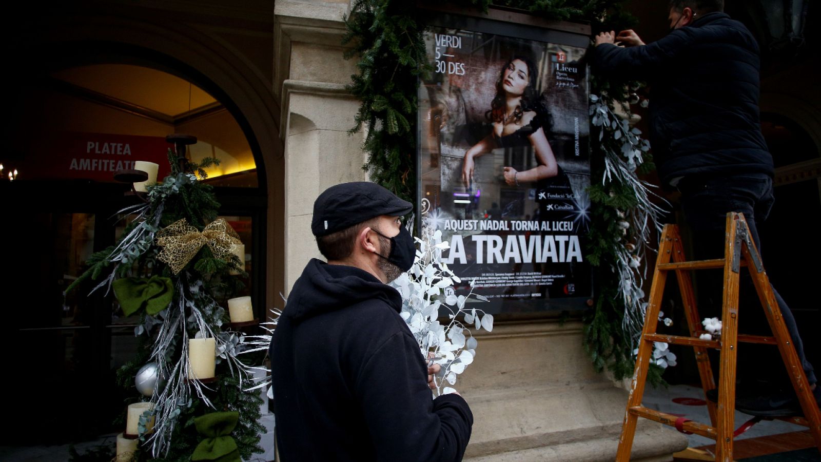 Dos trabajadores decoran la fachada del Gran Teatre del Liceu