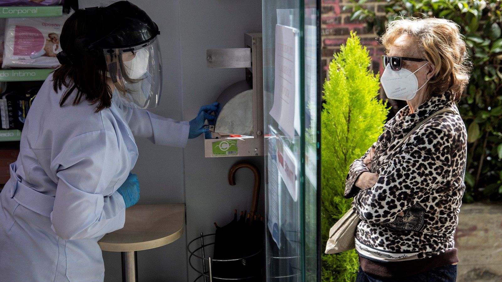 Una persona recoge su mascarilla en una farmacia de Madrid, este mayo