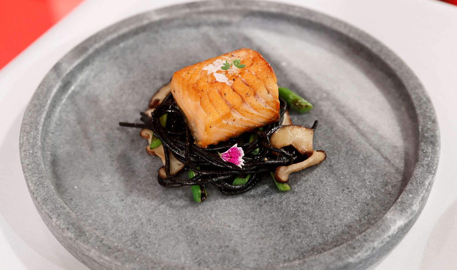 Salmón a la parrilla, espagueti negro, setas y ajetes