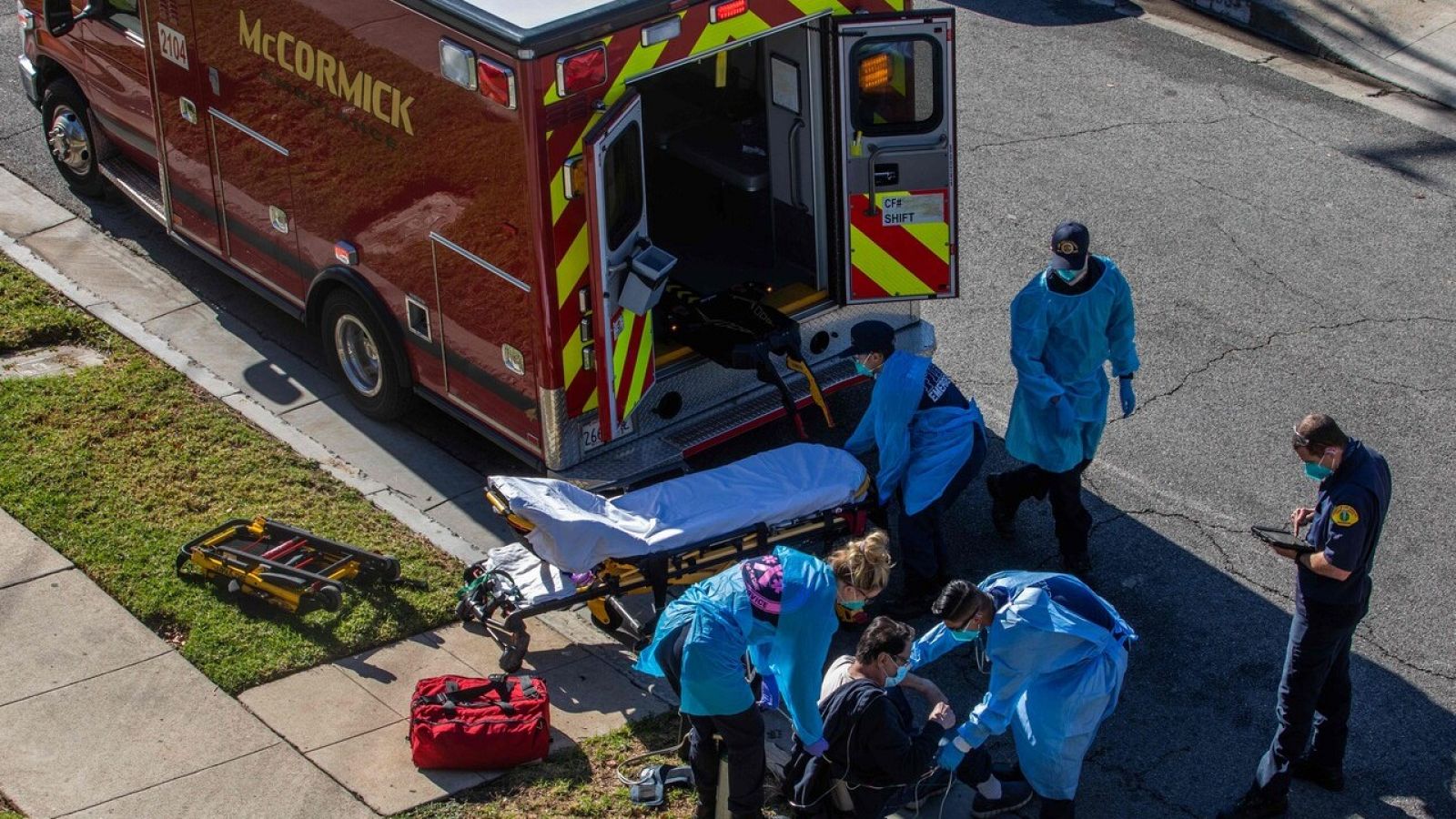 Un grupo de paramédicos administran oxígeno a un pciente en la calle