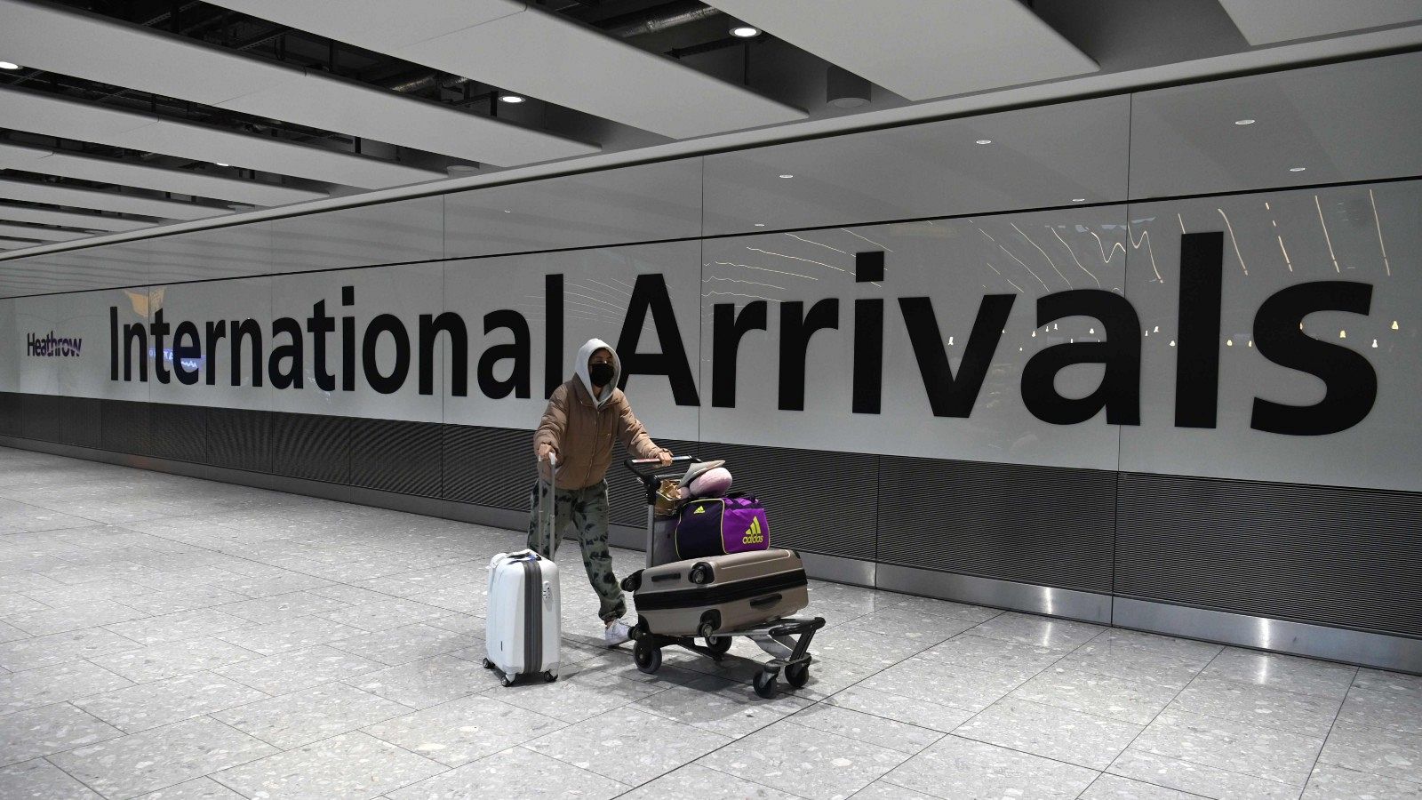 Un viajero, con maletas y mascarilla, llega al aeropuerto londinense de Heathrow