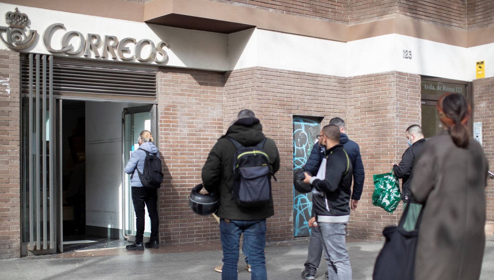 Varias personas hacen cola en una oficina de Correos de Barcelona