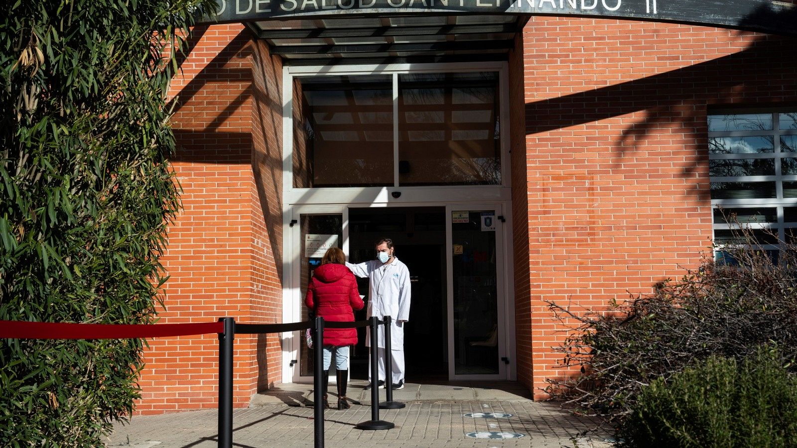 Un sanitario toma la temperatura de una mujer en un centro de salud de San Fernando de Henares
