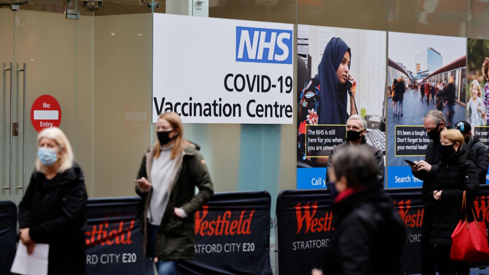 Gente esperando a entrar en un centro de vacunación NHS COVID-19 en Londres.