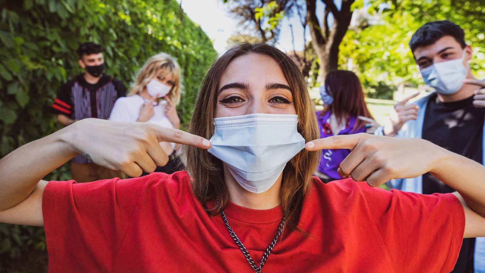 Grupo de adolescentes que posan mostrando sus máscaras protectoras