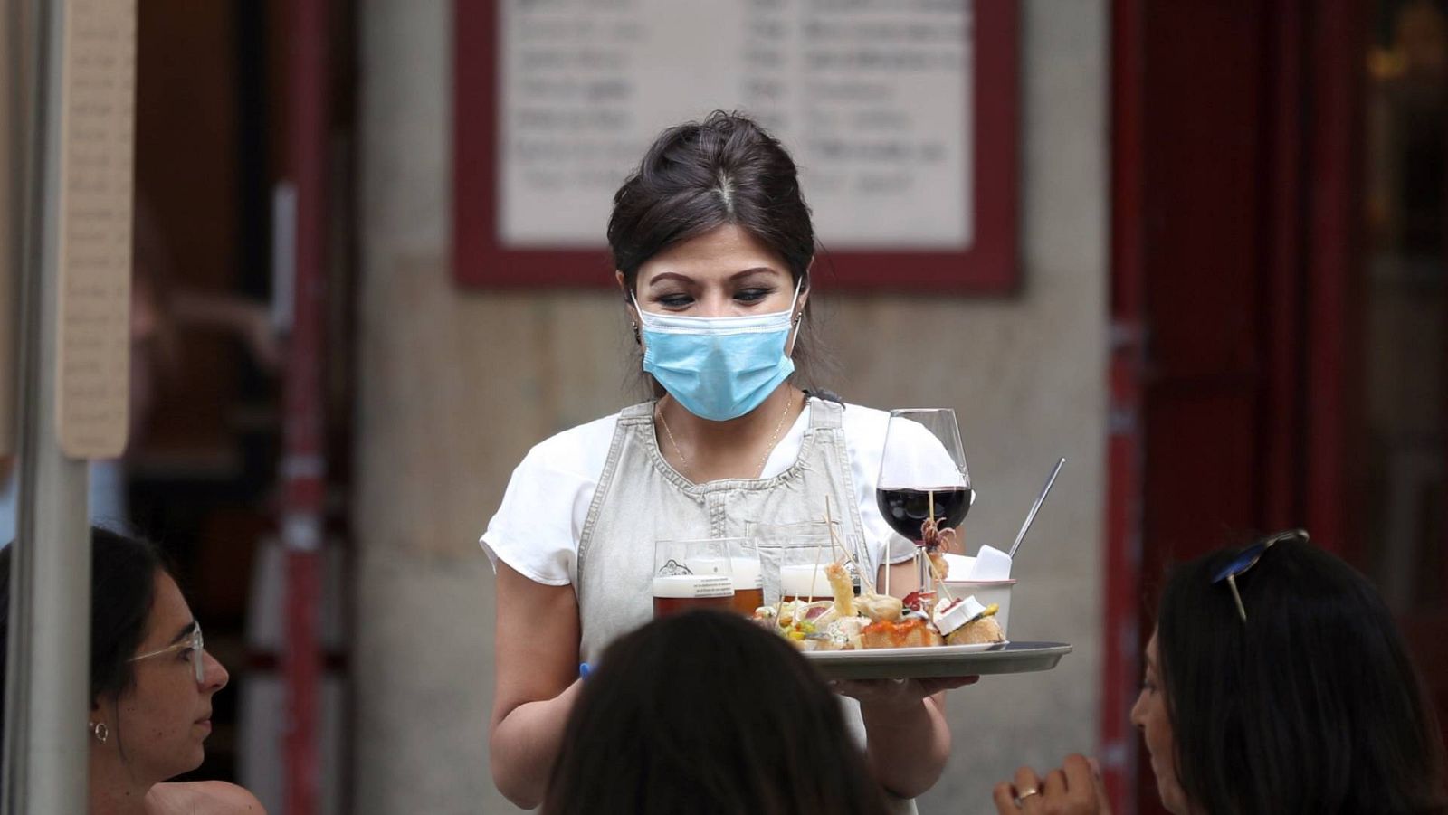 Una mujer trabaja como camarera en un bar de Bilbao