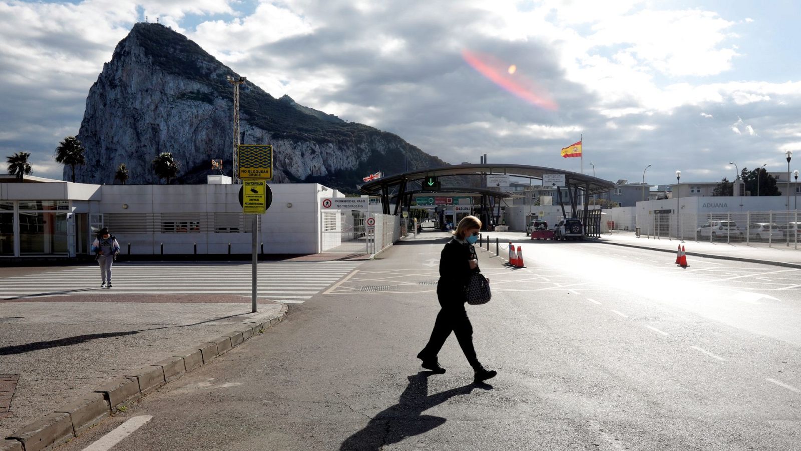 .Una mujer cruza frente a la zona de control de Gibraltar