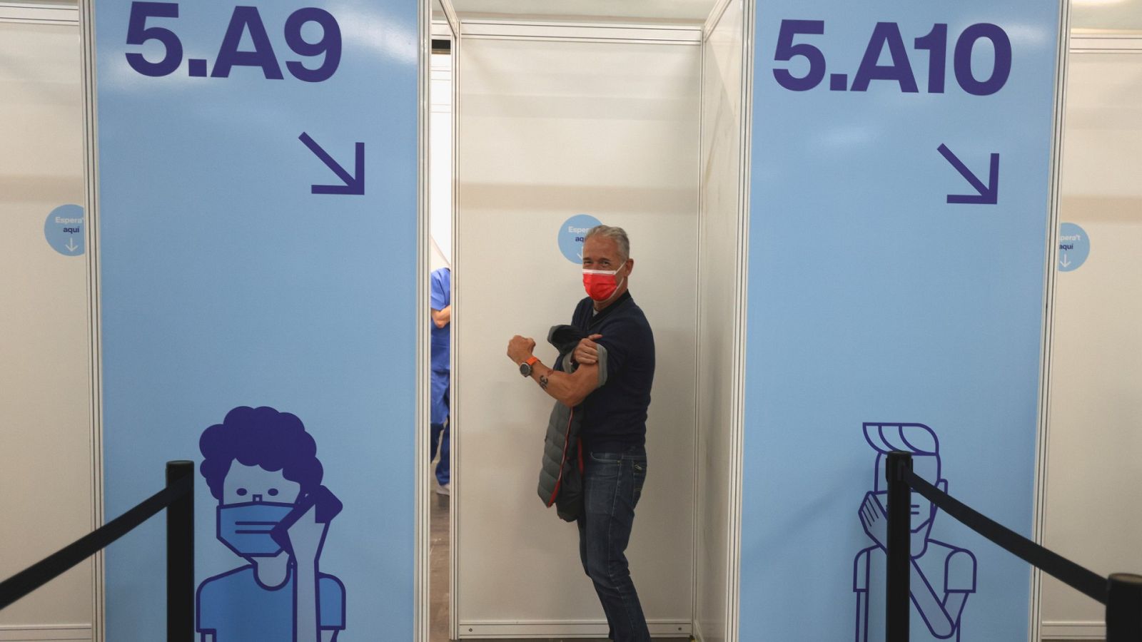 Un hombre espera para vacunarse contra la COVID-19 en la Fira de Montjuic, en Barcelona