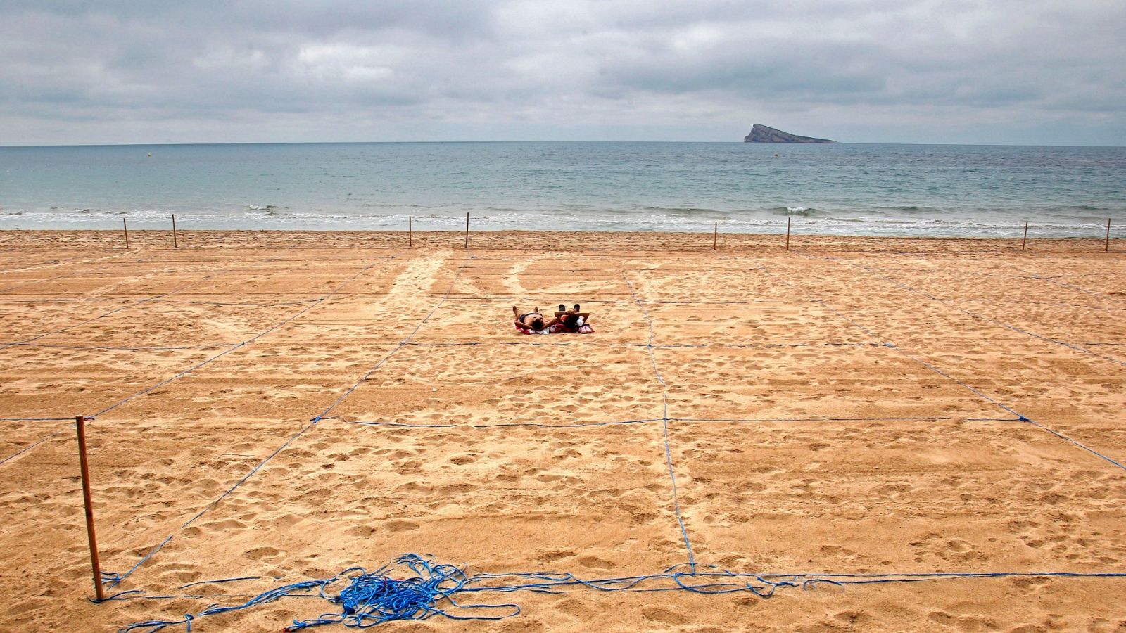 Dos personas en una playa parcelada en Benidorm