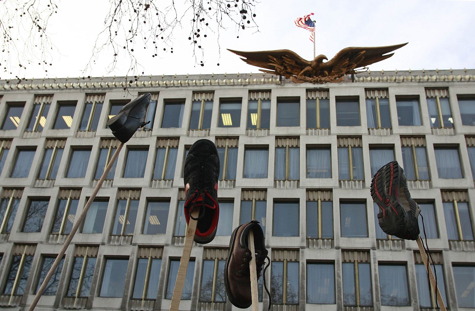 Protesters wave shoes as they gather outside the U.S. Embassy  in central London