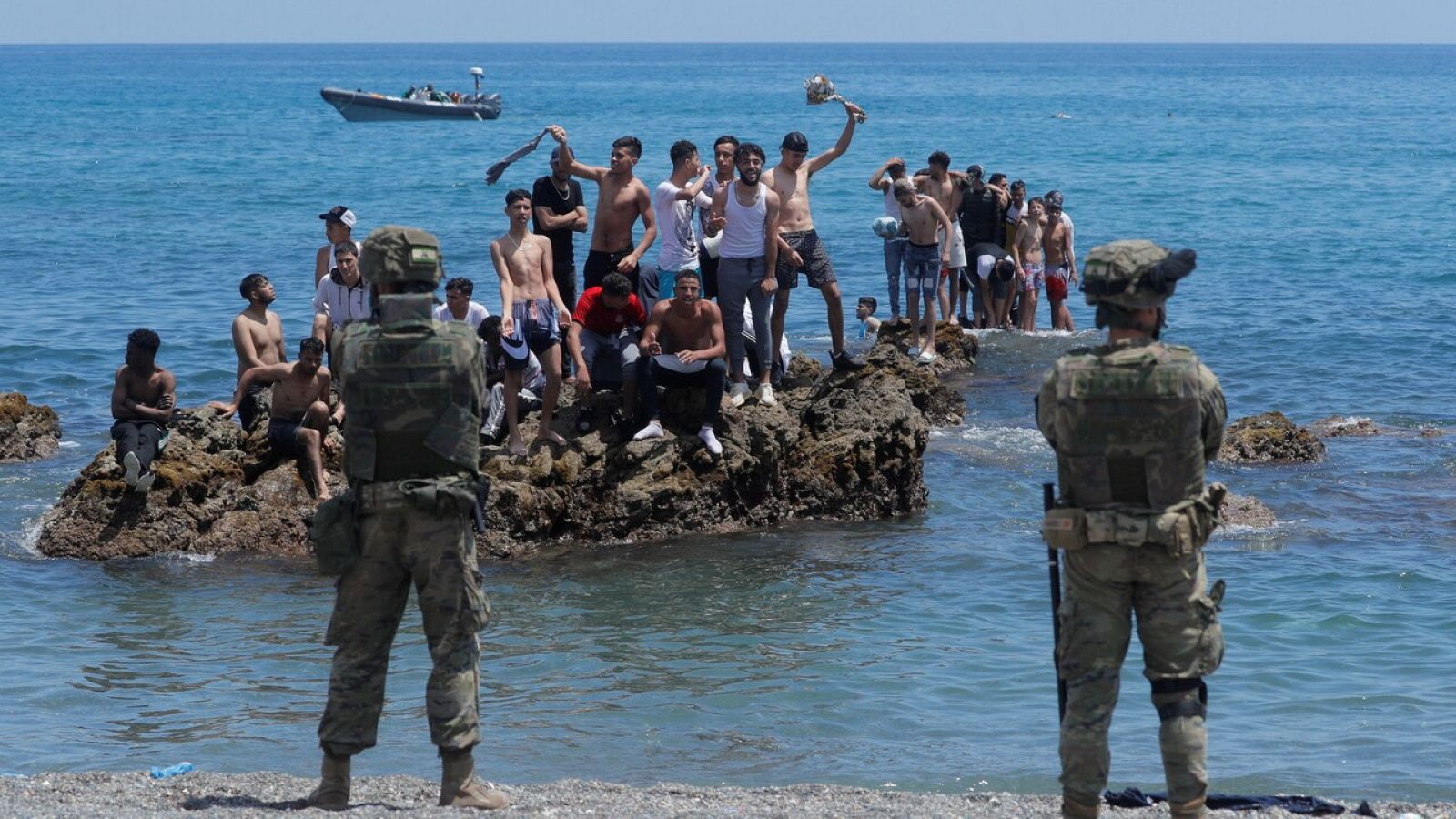 Migrantes frente a soldados españoles en la playa ceutí de El Tarajal