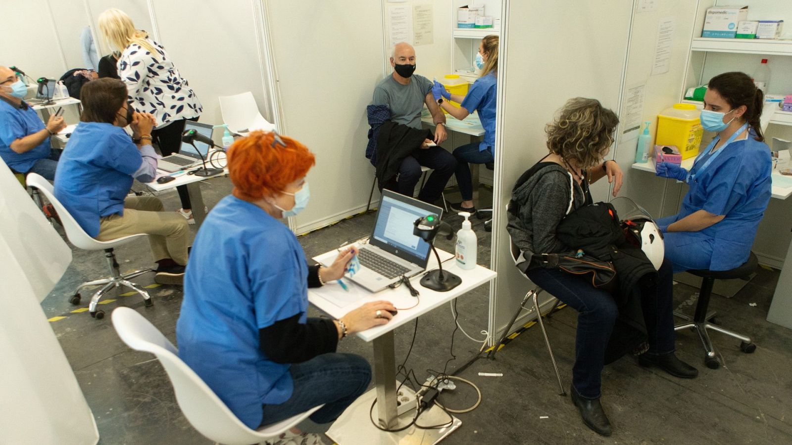 Una enfermera vacuna contra la COVID-19 a una mujer en el centro de vacunación de la Fira de Barcelona