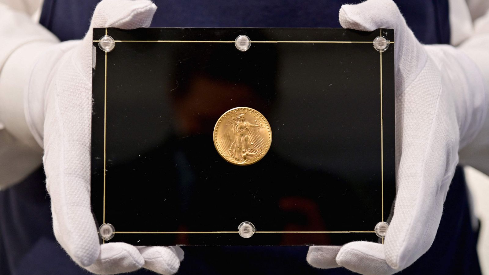 Un empleado de Sotheby's sostiene la "Mona lisa de las monedas" de 1933